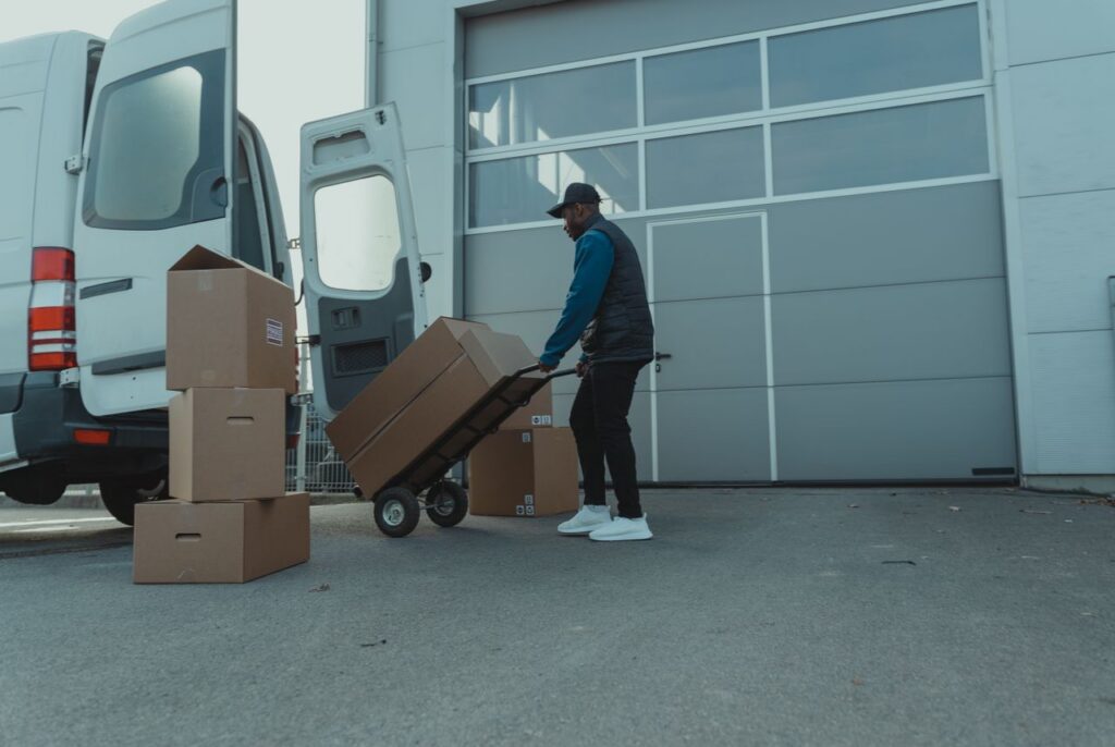 The Entrepreneur’s Guide to Turning Ideas Into Profitable Courier unloading packages from a delivery van at a warehouse entrance. Efficient distribution.