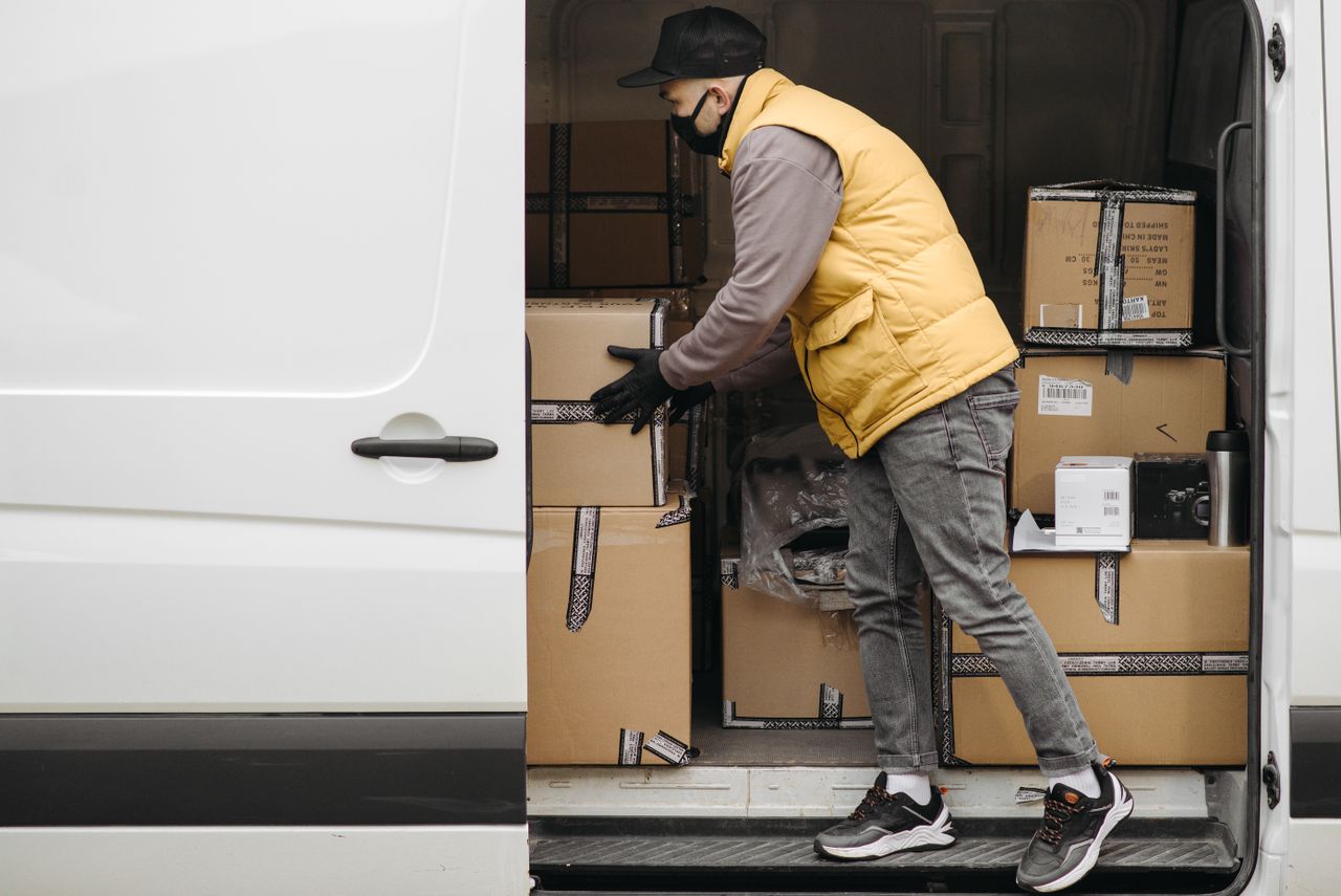 Overcoming Challenges Lessons Every Entrepreneur Must Learn Delivery worker organizing packages in a van, showcasing modern logistics.